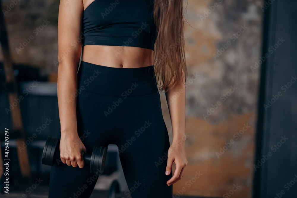 Young woman posing at the camera with dumbbells in her hands. Young woman posing at the camera with dumbbells in her hands.