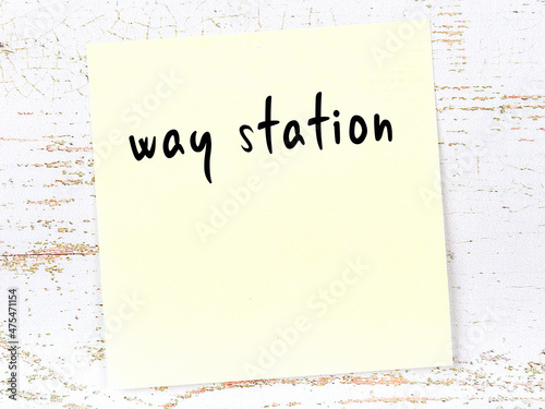 Yellow sticky note on wooden wall with handwritten word way station photo