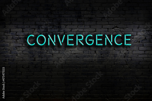 Fotografi Night view of neon sign on brick wall with inscription convergence
