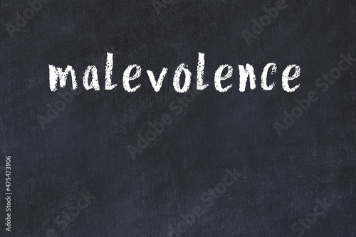 Inscription malevolence painted on white brick wall