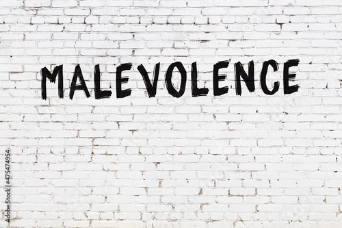 White wall with black paint inscription malevolence on it