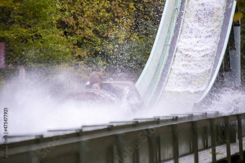 Extreme water flume ride in the amusement park with green trees in the background photo