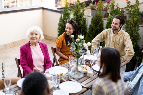 Family and friends celebrating at dinner on a rooftop terrace. Storytelling footage of a multiethnic group of people dining on a rooftop. Family and friends make a reunion at home