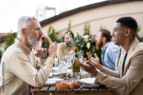 Family and friends celebrating at dinner on a rooftop terrace. Storytelling footage of a multiethnic group of people dining on a rooftop. Family and friends make a reunion at home