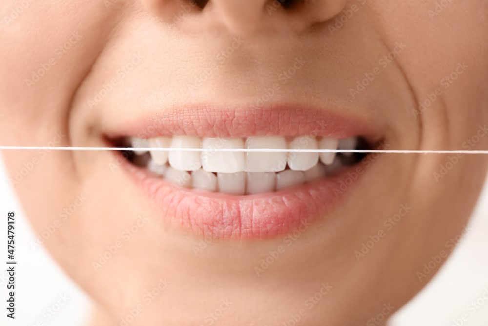 Fototapeta premium Woman with dental floss on white background, closeup