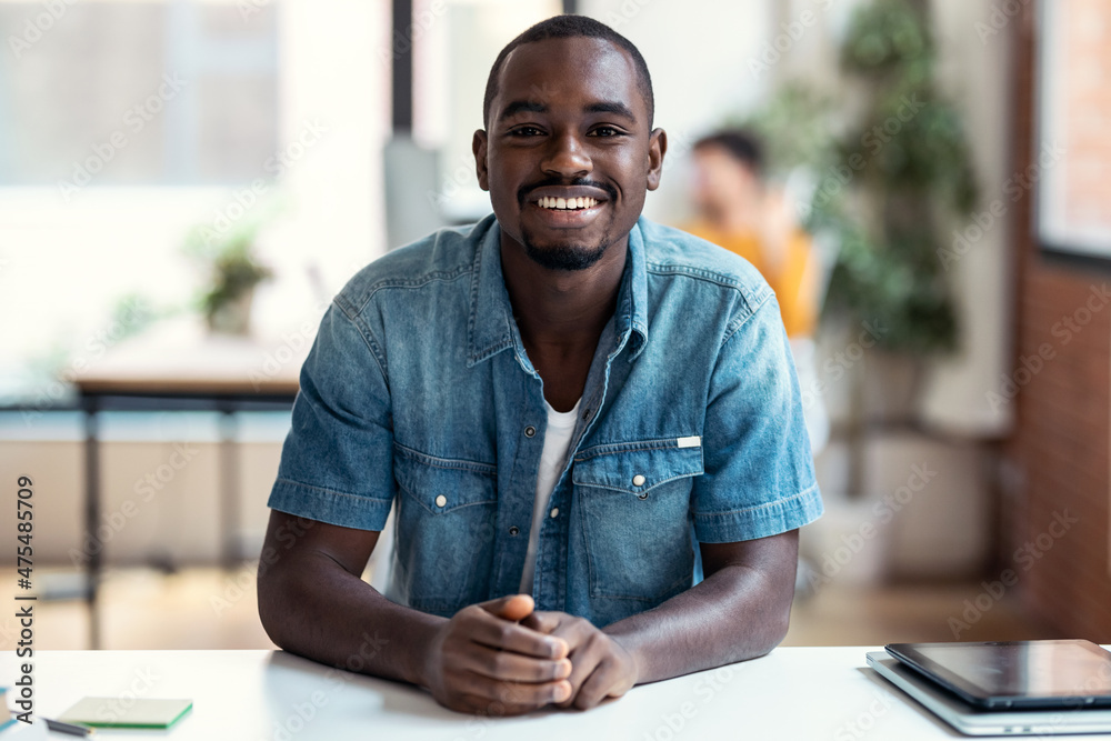 Afro-american business man entrepreneur looking at camera while working in a modern startup.
