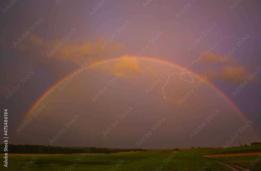 Lightning with with beautiful rainbow, fresh rain in the summer field landscape Lightning with with beautiful rainbow, fresh rain in the summer field landscape