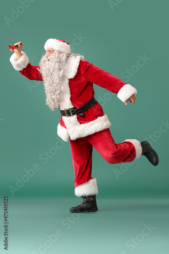 Santa Claus with Christmas bell on green background © Pixel-Shot