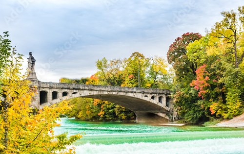 Turquoise Isar river and autumn landscape of maximilian bridge in Munich - Germany © streetflash