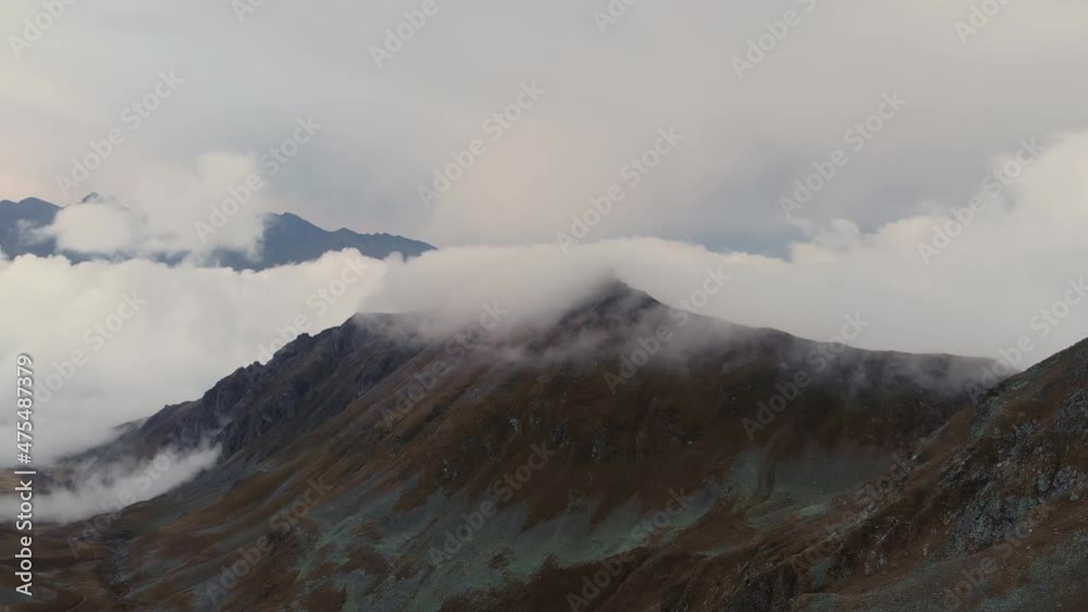 Evening time-lapse of the movement of clouds in the mountains. Overflowing cloudiness over mountain ridges and peaks. Aerial view. Changing of the climate. Global warming Evening time-lapse of the movement of clouds in the mountains. Overflowing cloudiness over mountain ridges and peaks. Aerial view. Changing of the climate. Global warming