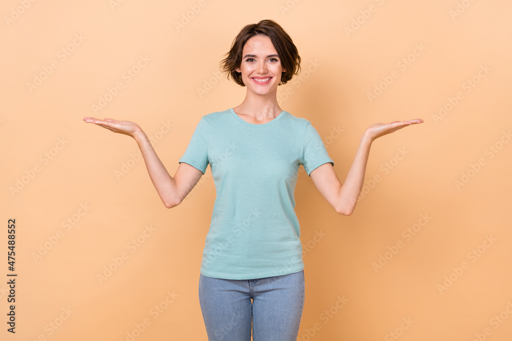 Photo of youth cheerful woman promoter hold hands advertise suggest recommend isolated over beige color background Photo of youth cheerful woman promoter hold hands advertise suggest recommend isolated over beige color background