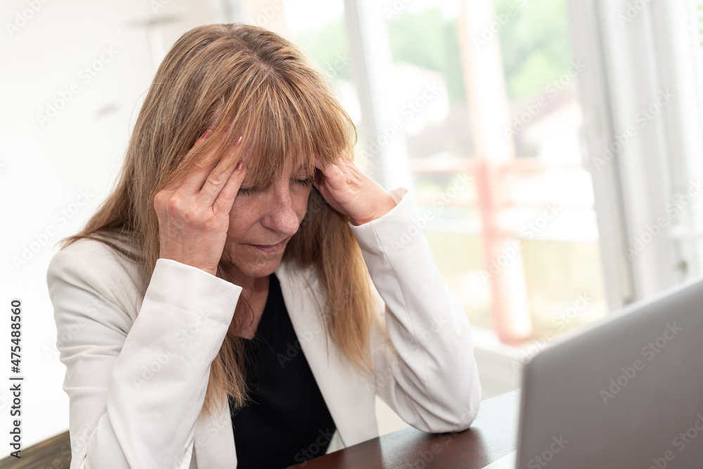 Exhausted businesswoman sitting in office Exhausted businesswoman sitting in office