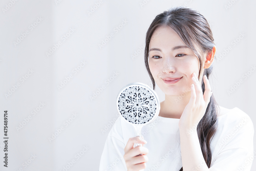 Beautiful young Asian (Japanese) woman smiling with concern for her skin condition Close-up Copy space available Beautiful young Asian (Japanese) woman smiling with concern for her skin condition Close-up Copy space available