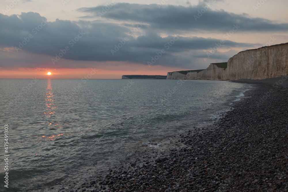 Sunset over the Seven Sisters chalk cliffs coastline, East Sussex. Low angle view.