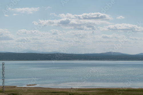 The landscape of Busko Lake in summer with low water levels and mountains in the background