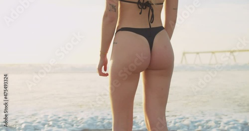 Back view of a sexy woman in the beach with a nice ass, slim and fit hot body