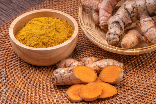 Curry Powder and Turmeric root in wooden plate, Curry Powder on a wooden table background.