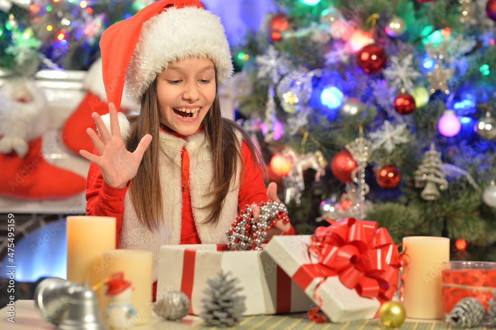 Portrait of happy girl in  Santa Claus hat with gift