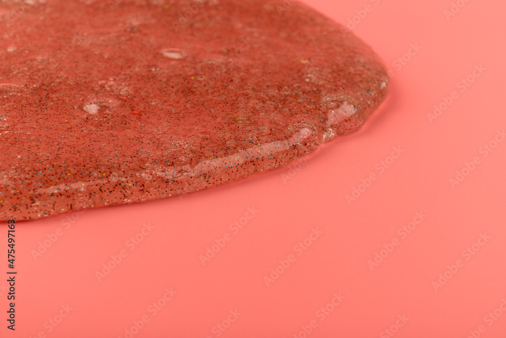Coral transparent slime with bubbles inside on pink background. Kids toy slime.