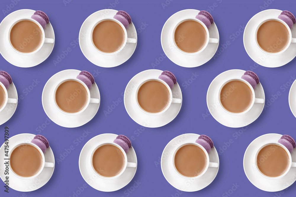 Pattern of coffee cups with lilac dessert cake macaroon on trendy very peri background Pattern of coffee cups with lilac dessert cake macaroon on trendy very peri background