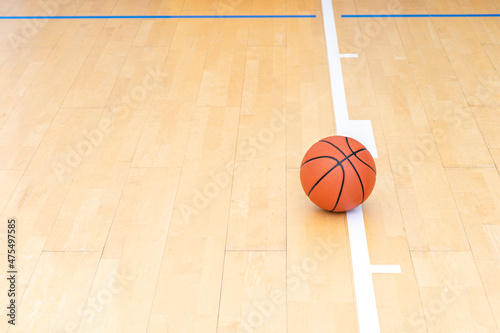 Basketball on hardwood court floor with natural lighting. Workout online concept. Horizontal sport theme poster, greeting cards, headers, website and app © Augustas Cetkauskas