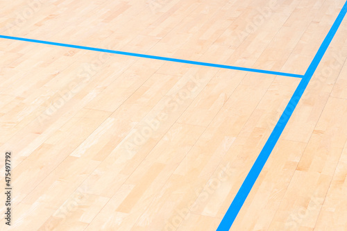 Wooden floor basketball, badminton, futsal, handball, volleyball, football, soccer court. Wooden floor of sports hall with marking blue lines on wooden floor indoor, gym court