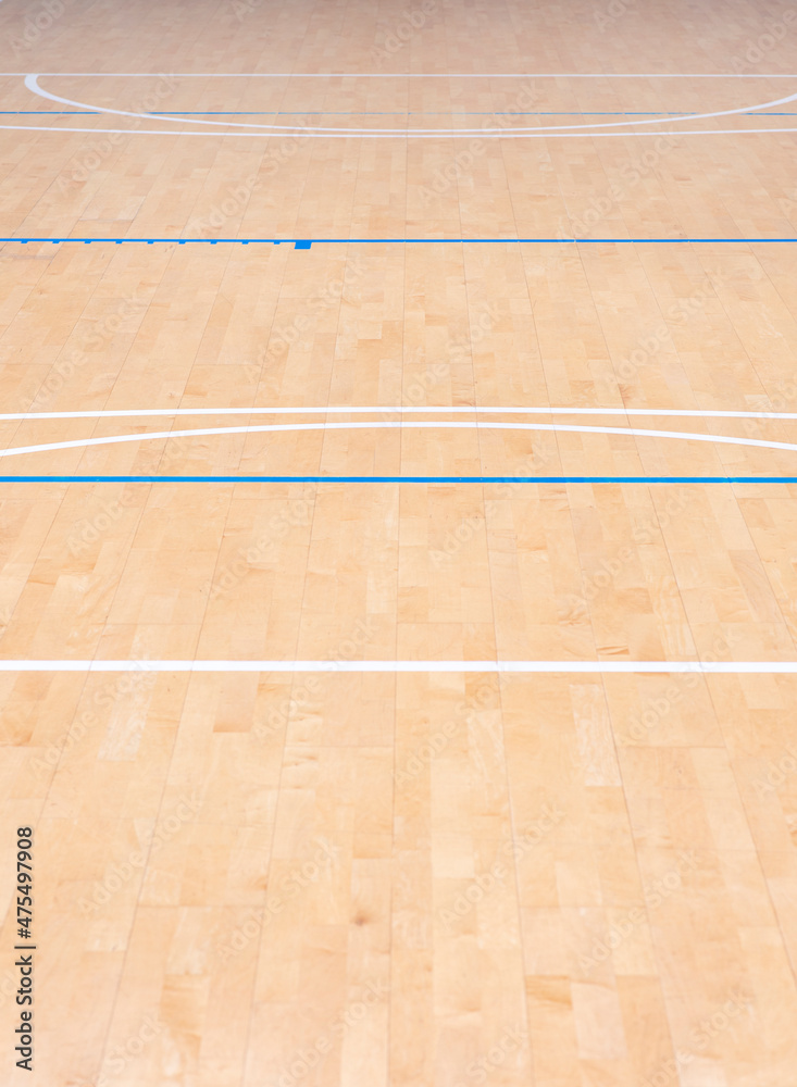 Obraz premium Wooden floor basketball, badminton, futsal, handball, volleyball, football, soccer court. Wooden floor of sports hall with marking blue and white lines on wooden floor indoor, gym court