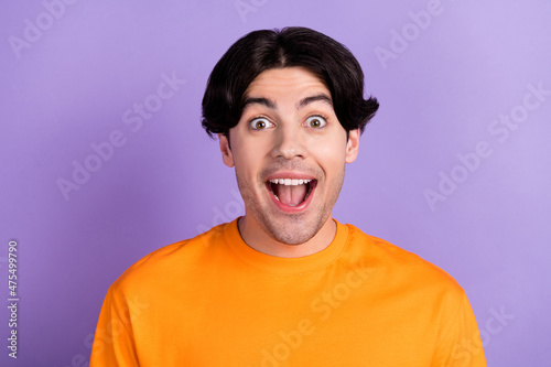 Photo of amazed shocked excited happy man good mood enjoy discount isolated on purple color background