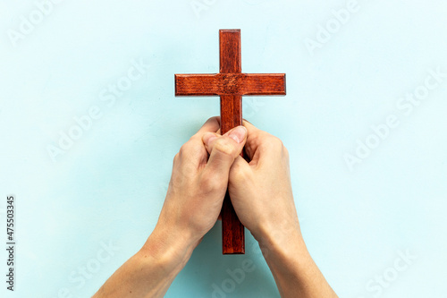 Hands holding christian wooden cross. Faith and prayer concept