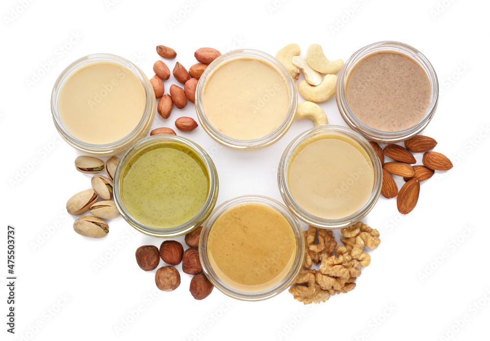 Jars with butter made of different nuts on white background, top view Jars with butter made of different nuts on white background, top view