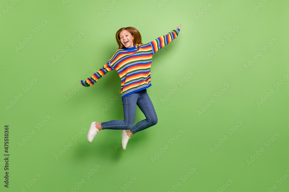 Full length body size view of attractive funky carefree cheerful girl jumping having fun isolated over bright green color background