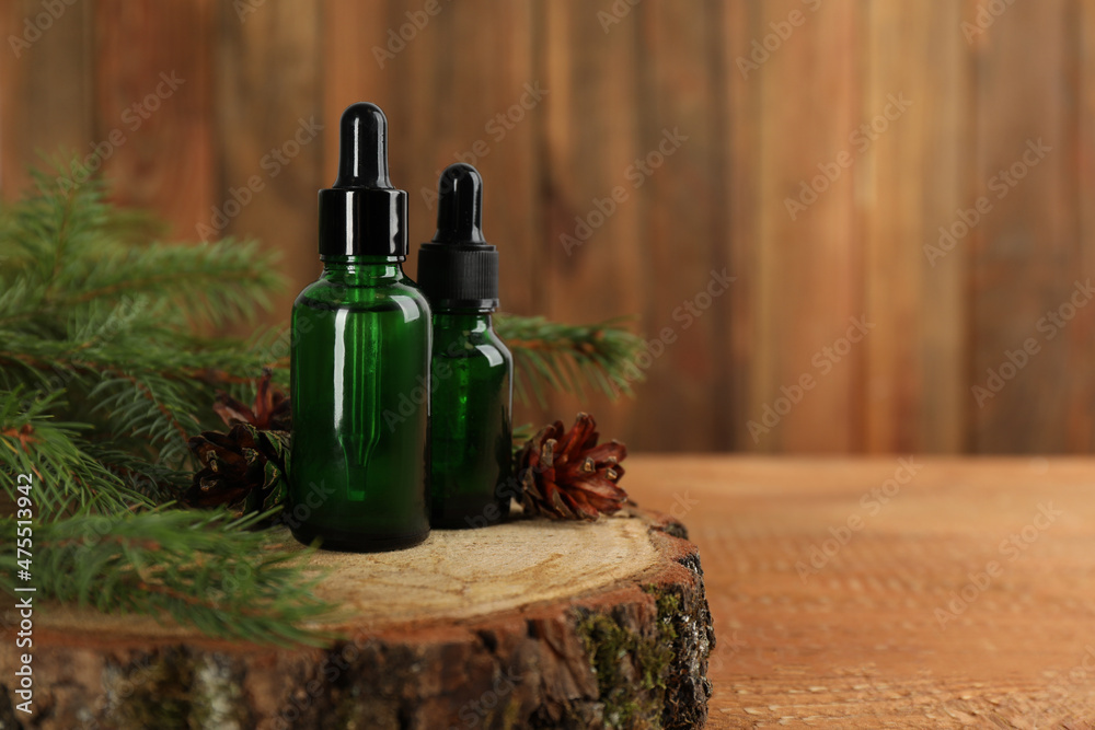Pine essential oil, cones and branches on wooden table. Space for text Pine essential oil, cones and branches on wooden table. Space for text