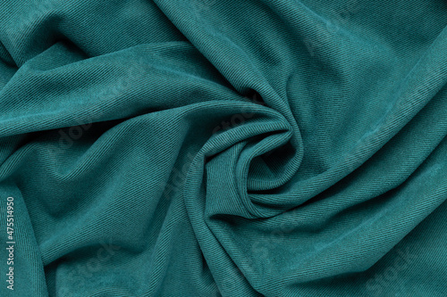 green fabric background. spiral wrinkled cloth pattern. Textile and texture concept