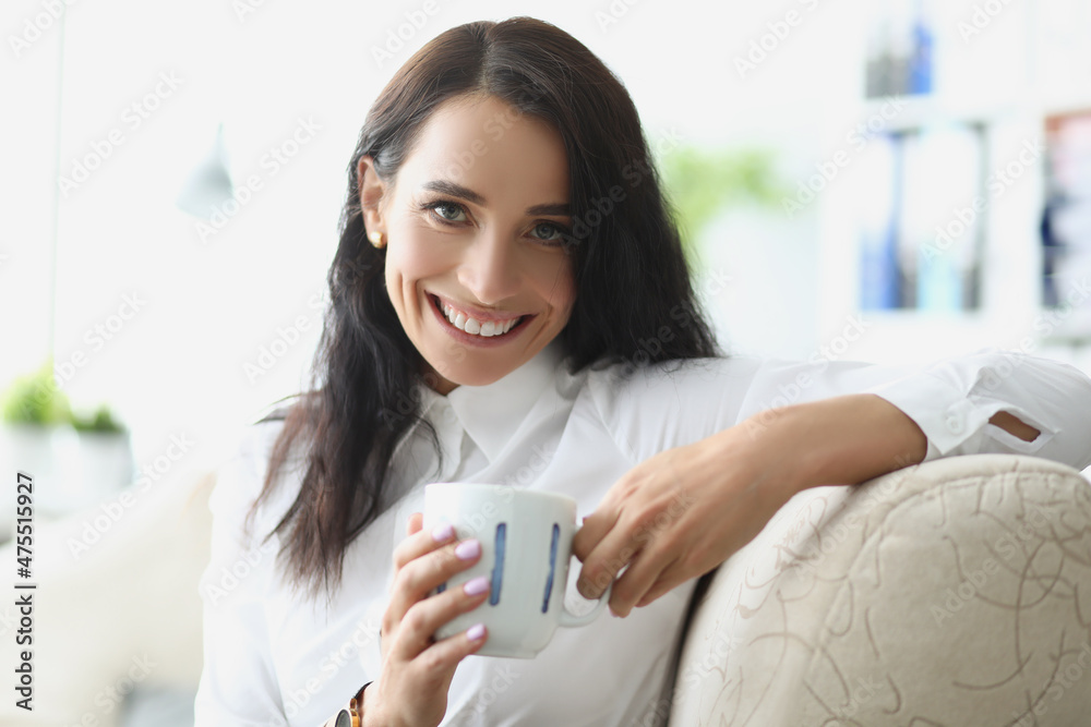 Beautiful brunette young woman chilling with cup of hot drink