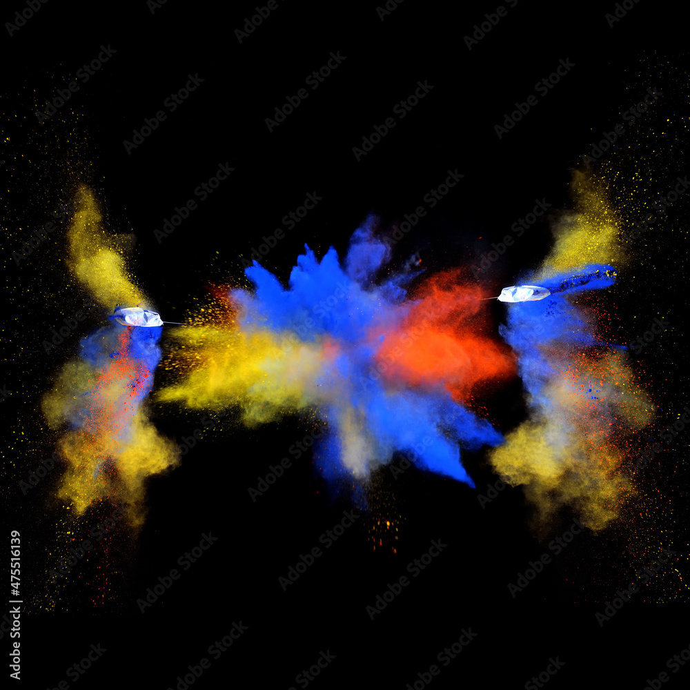 Blue and yellow bizarre forms of powder paint explode in front of a black background to give off fantastic multi colors and forms.