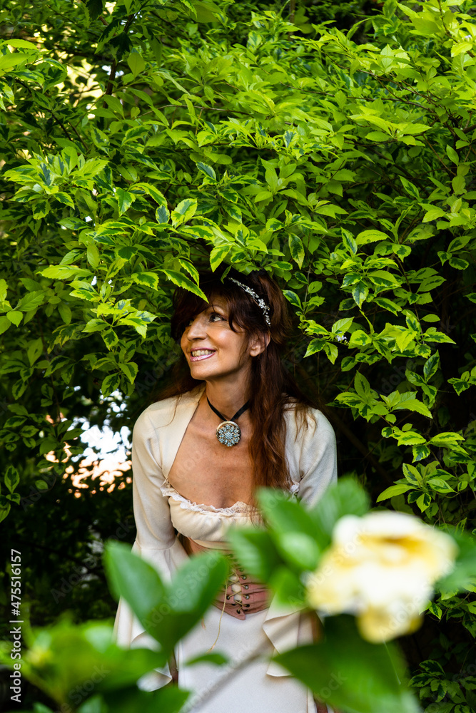 Singer in garden, green space, medieval dress, jasmine, plants background Singer in garden, green space, medieval dress, jasmine, plants background