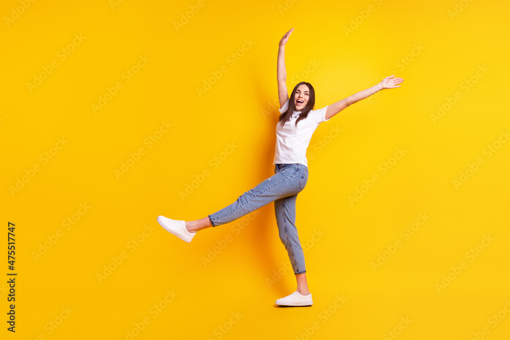 Full size profile side photo of young cheerful girl have fun walk ear casual clothes isolated over yellow color background