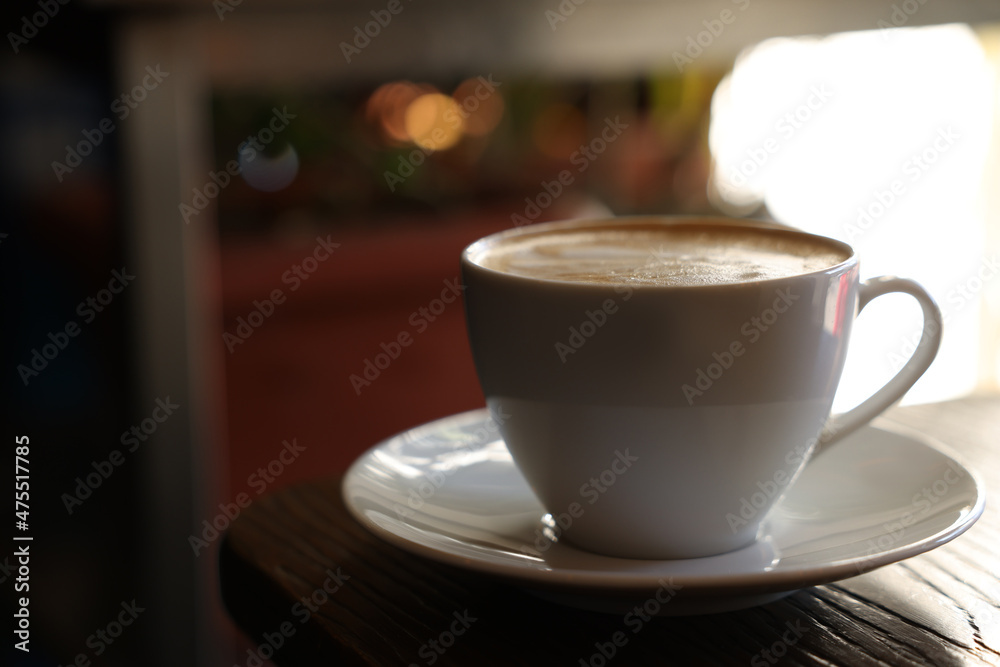 Cup of aromatic coffee with foam on table in cafe. Space for text Cup of aromatic coffee with foam on table in cafe. Space for text