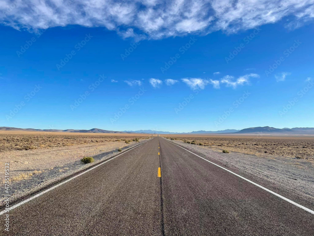 Beautiful panoramic view of a deserted and endless road through the mountains, Nevada, United States. Beautiful panoramic view of a deserted and endless road through the mountains, Nevada, United States.