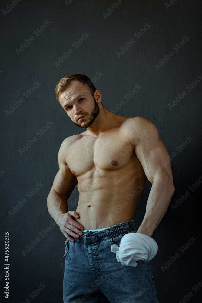 young man, brutal appearance, with a beautiful torso, bodybuilder, in the studio on a black background, BW photo