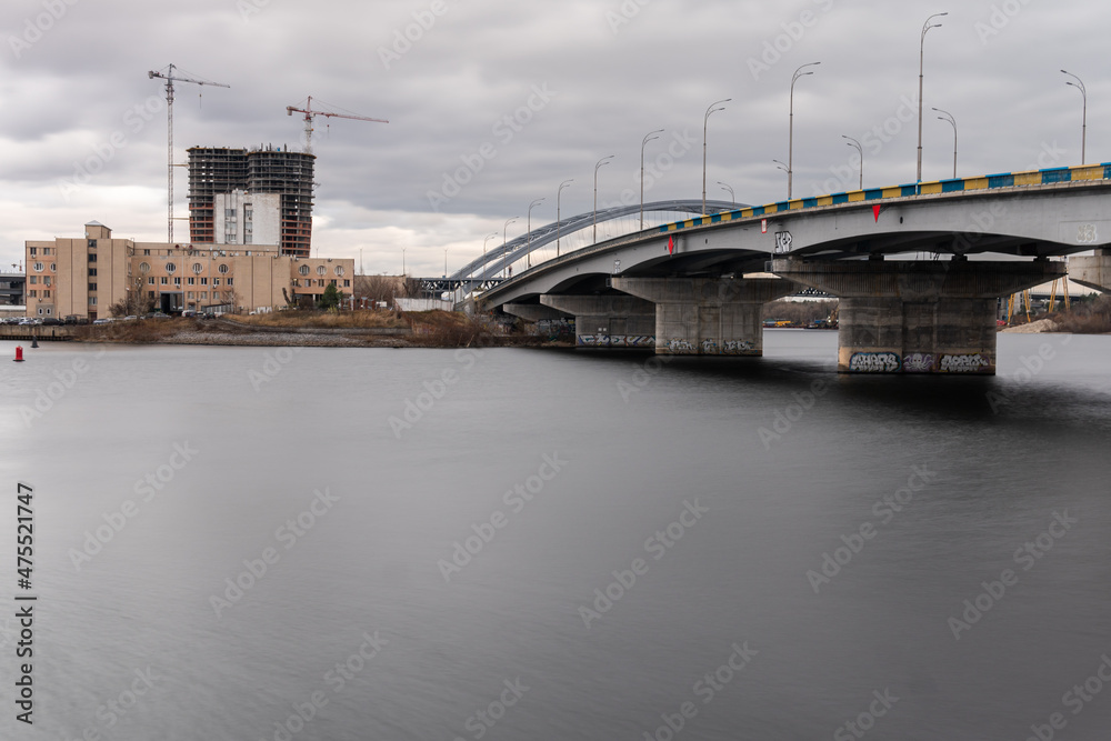 Kyiv (Kiev), Ukraine - November 30, 2021: Dnipro river, embankment, quayside, smooth water, bridges, stones, boats