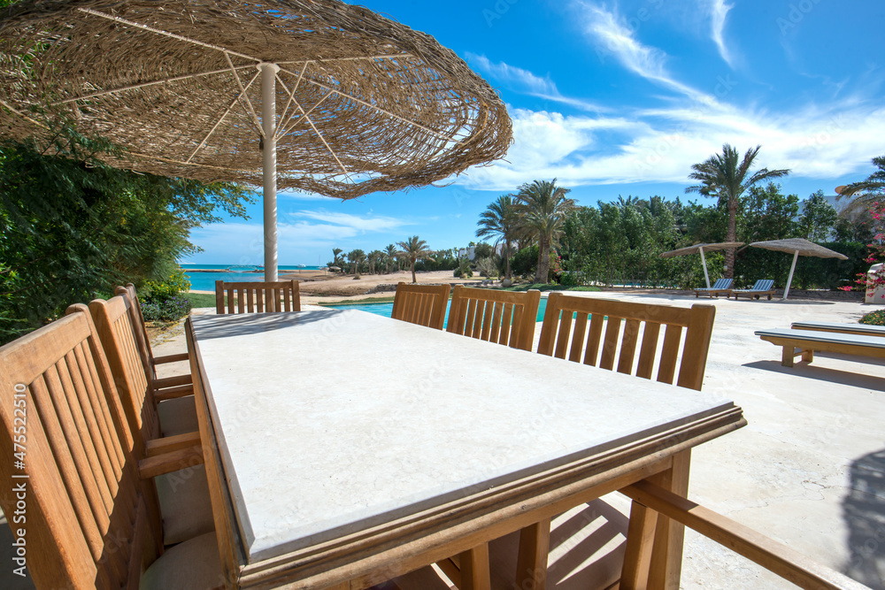 Swimming pool and outdoor dining area at at luxury tropical holiday villa resort Swimming pool and outdoor dining area at at luxury tropical holiday villa resort