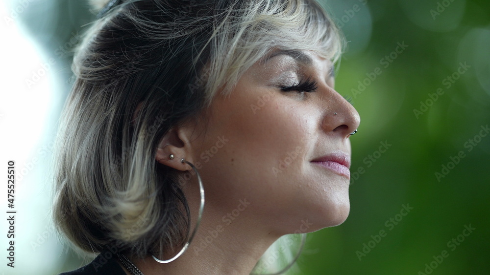 Young woman closing eyes in meditation and contemplation outside in nature Young woman closing eyes in meditation and contemplation outside in nature