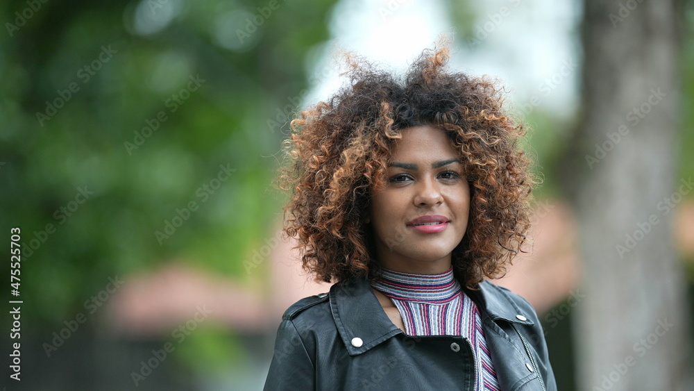 Young black woman walking forward. Confident Brazilian person walks outdoors Young black woman walking forward. Confident Brazilian person walks outdoors