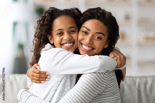 Closeup portrait of embracing black mother and daughter © Prostock-studio