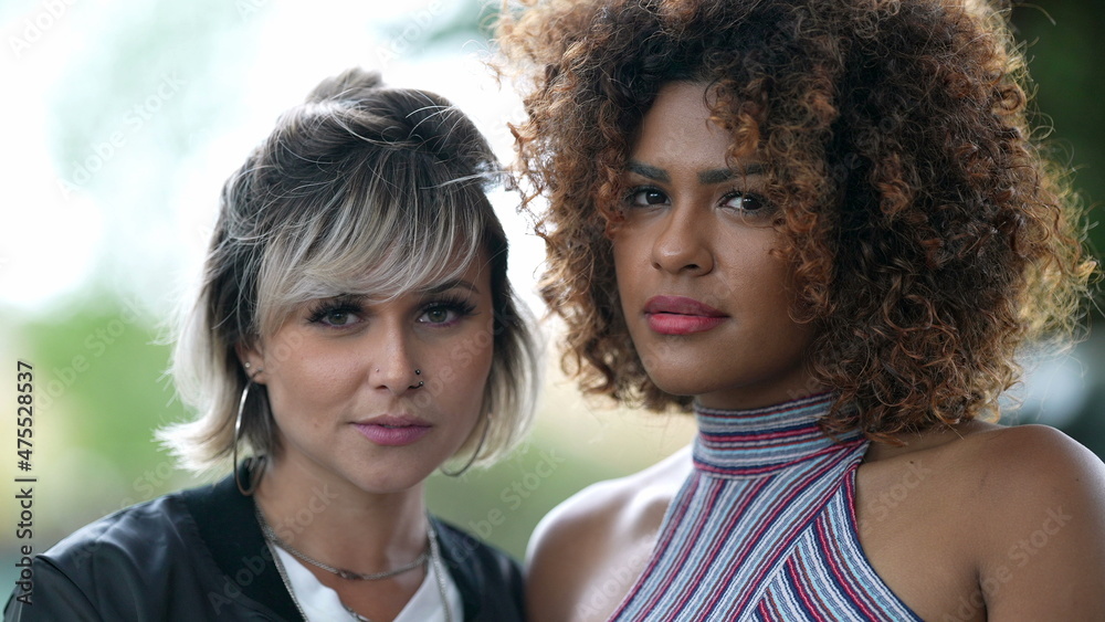 Two diverse women portrait faces looking at camera Two diverse women portrait faces looking at camera