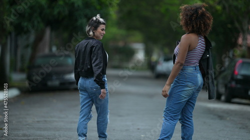 Two diverse women standing outside in street. Two friends hanging together