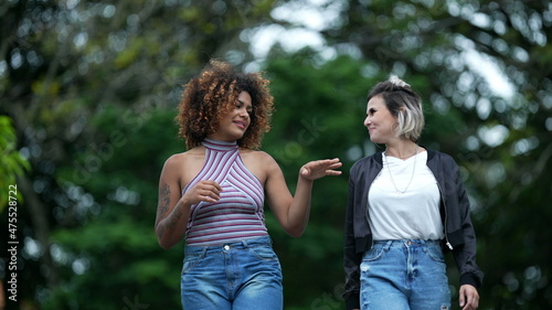 Two Brazilian friends hanging together outside in street. diverse friendship © Marco