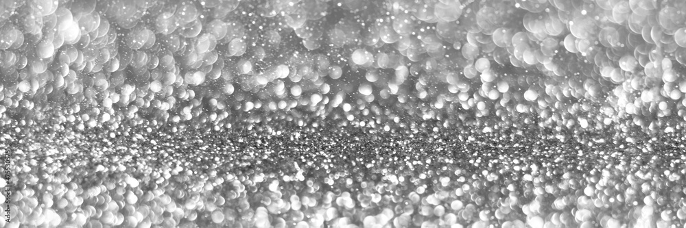 Silver sparkling glitter bokeh background, christmas texture. Holiday lights. Abstract defocused header. Wide screen wallpaper. Panoramic web banner with copy space for design Silver sparkling glitter bokeh background, christmas texture. Holiday lights. Abstract defocused header. Wide screen wallpaper. Panoramic web banner with copy space for design