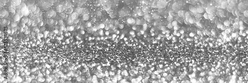Silver sparkling glitter bokeh background, christmas texture. Holiday lights. Abstract defocused header. Wide screen wallpaper. Panoramic web banner with copy space for design